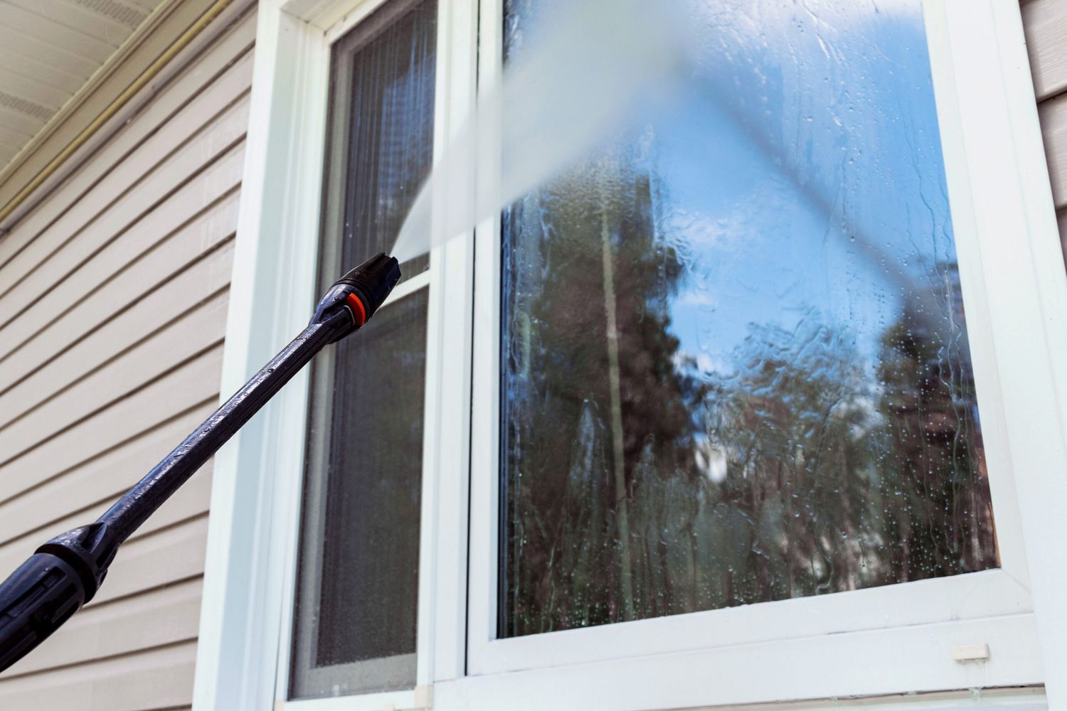 A window being pressure washed.