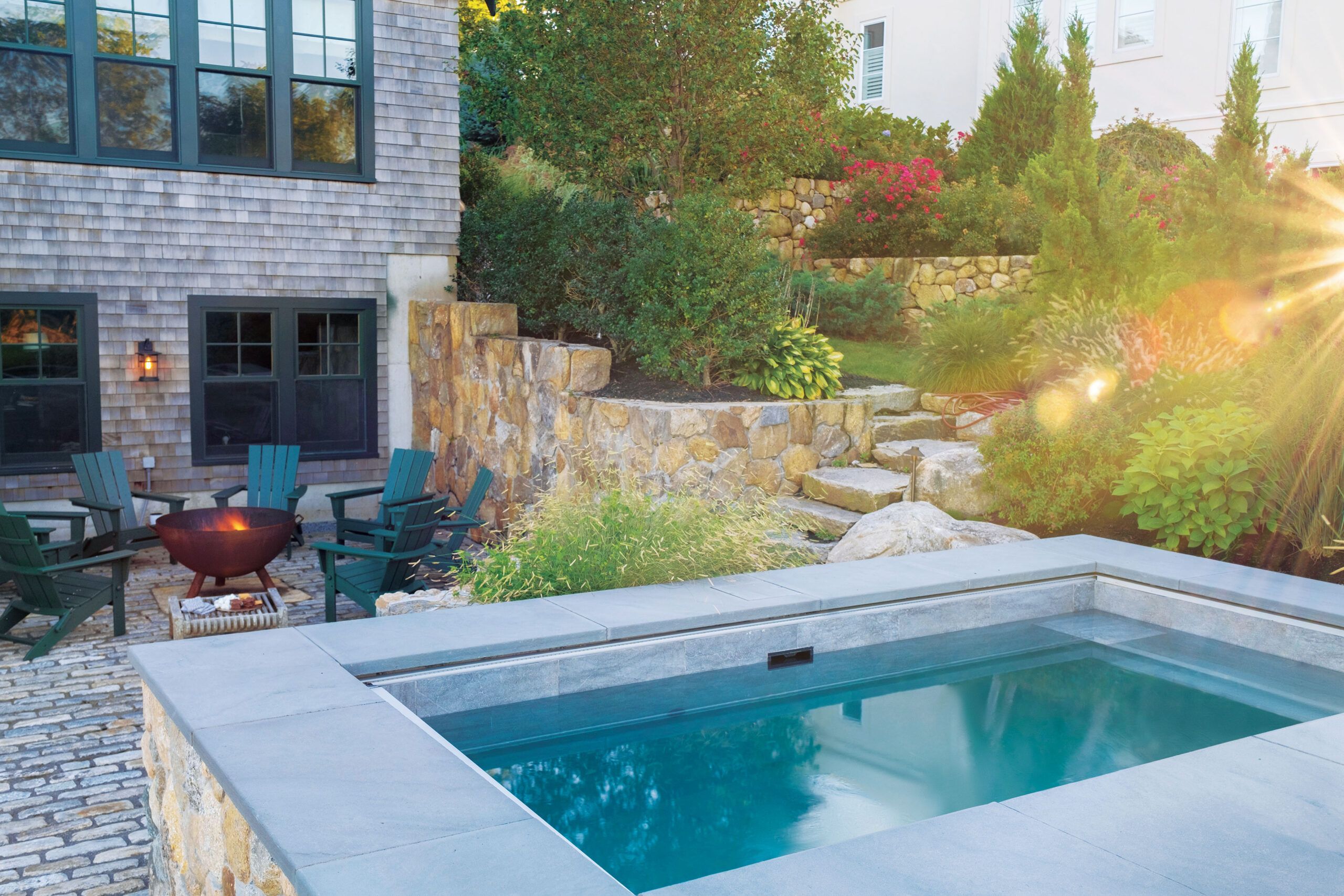 Blue water of a plunge pool near a firepit 