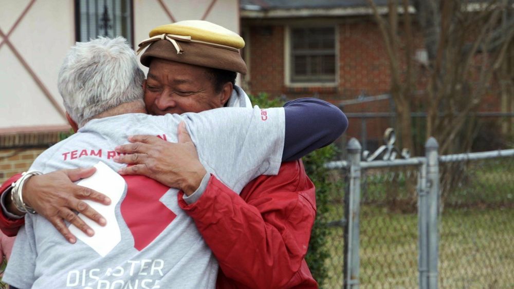 a Team Rubicon volunteer hugs a homeowner