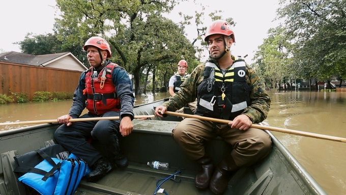 Team Rubicon volunteers row a boat into a flooded area