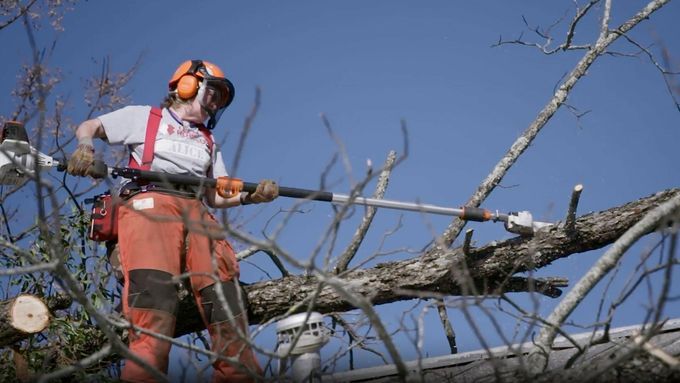 a Team Rubicon volunteer clears a dangerous tree branch