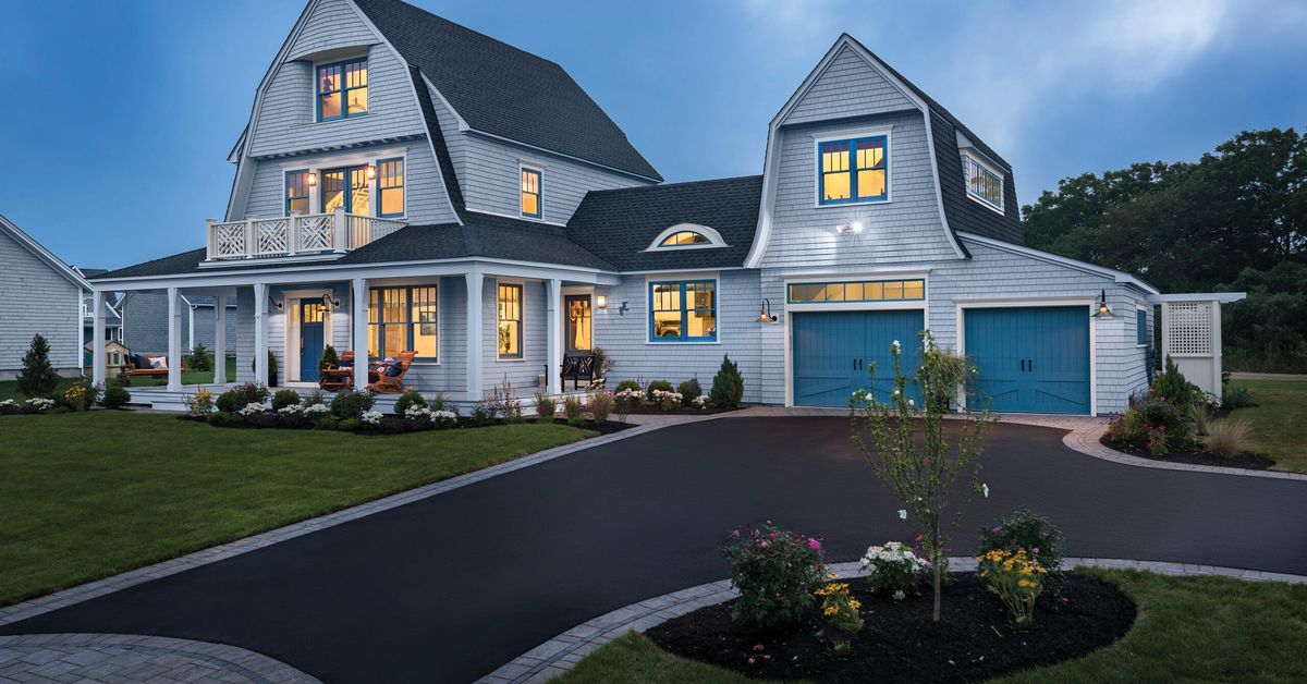 A brightly lit home with an asphalt driveway