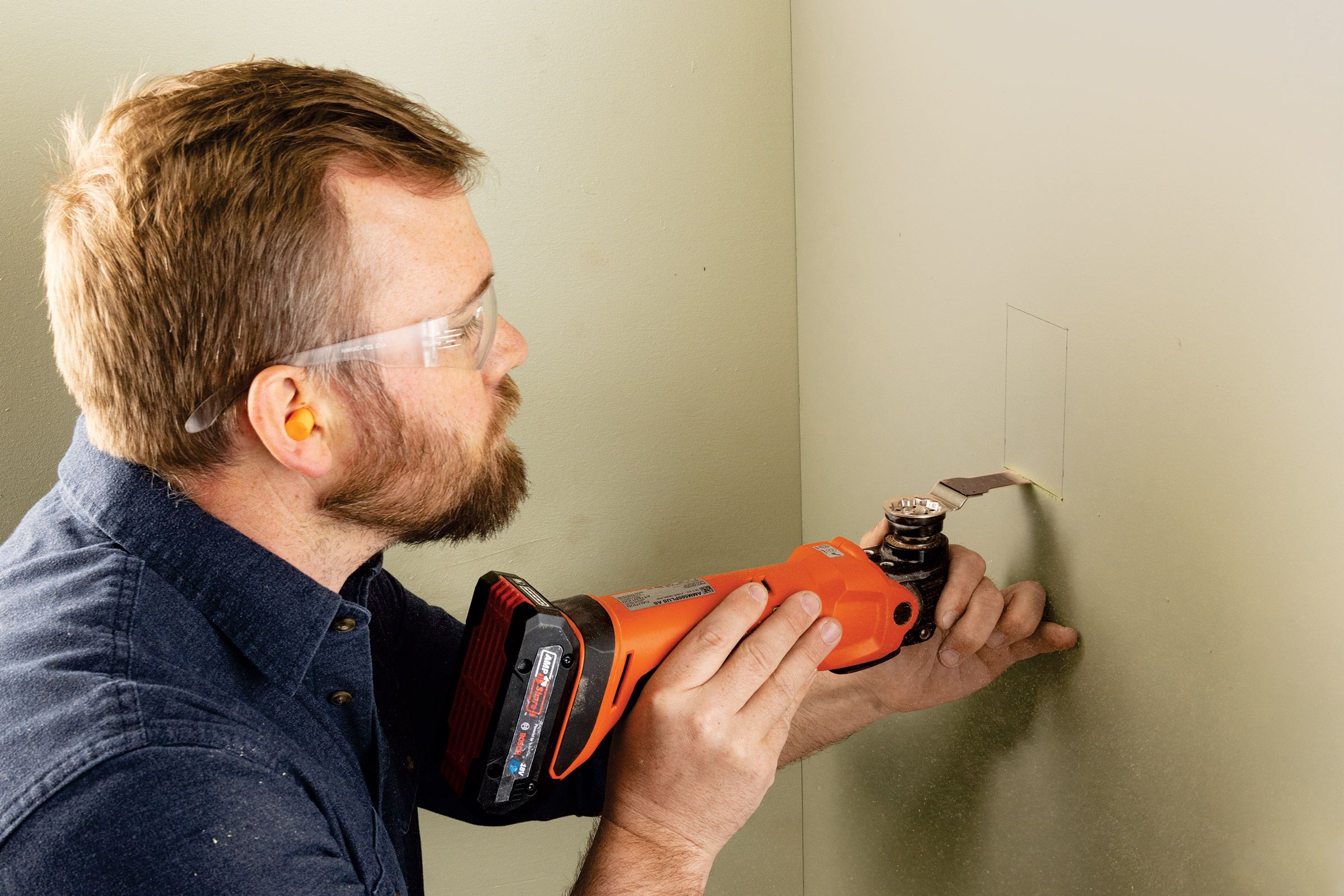 Nathan Gilbert cutting drywall with an oscillating multitool
