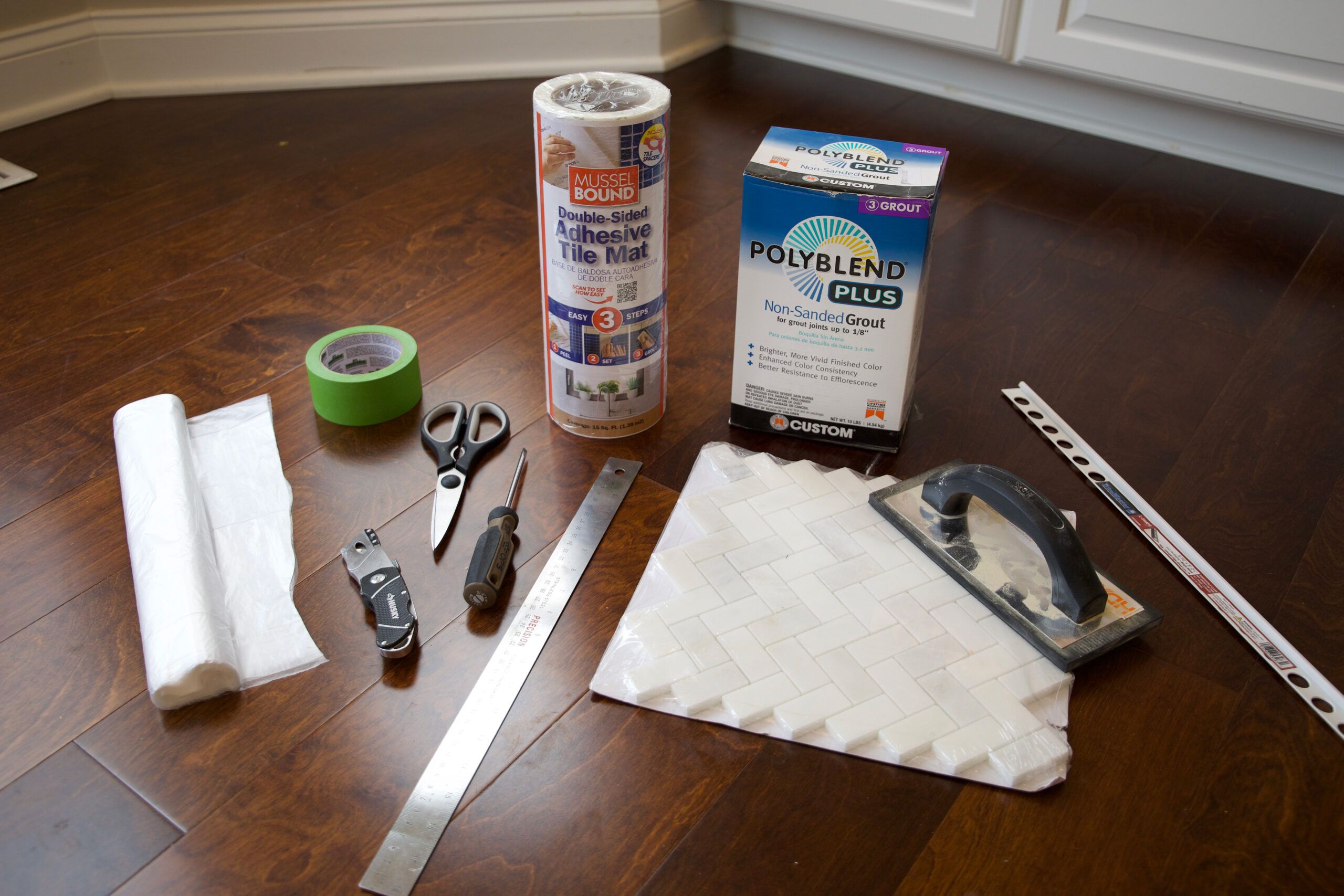 Supplies to add a kitchen backsplash using adhesive tile mats.