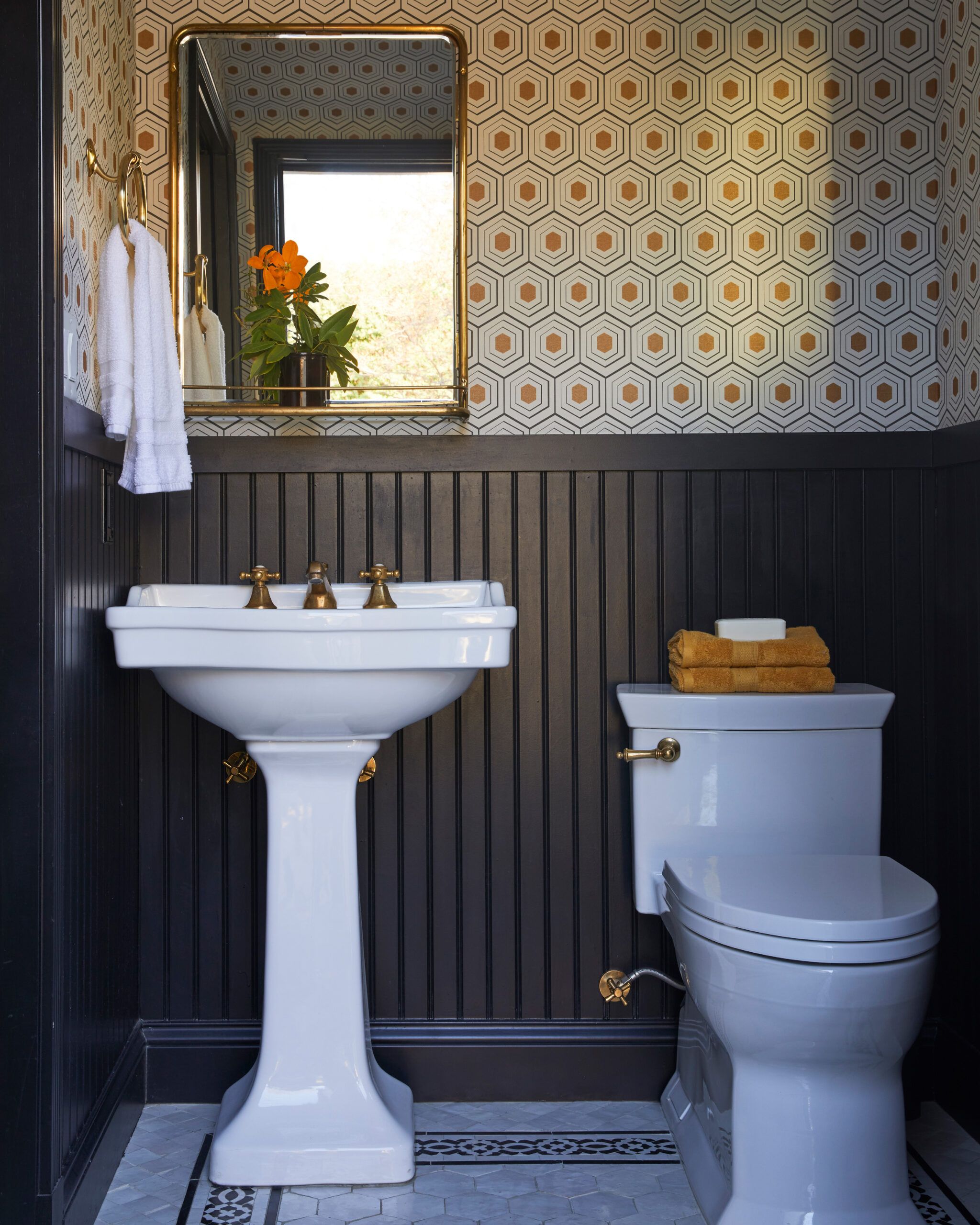 A traditional style pedestal sink and toilet in a powder room. 