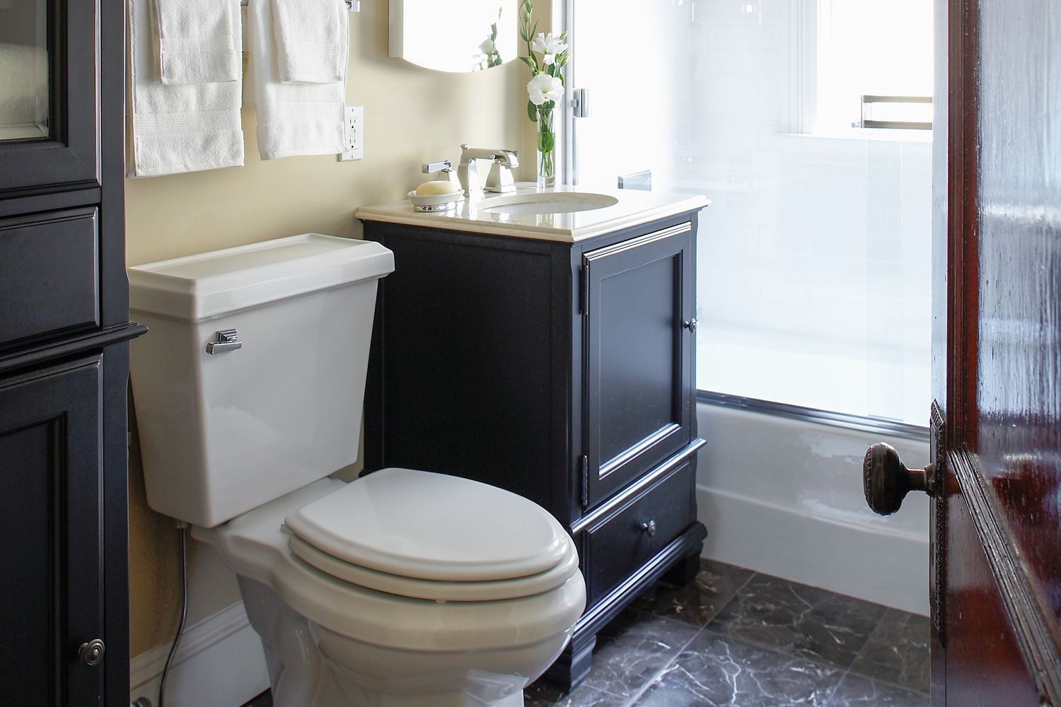 Looking into a classic bathroom with a toilet and cabinet.