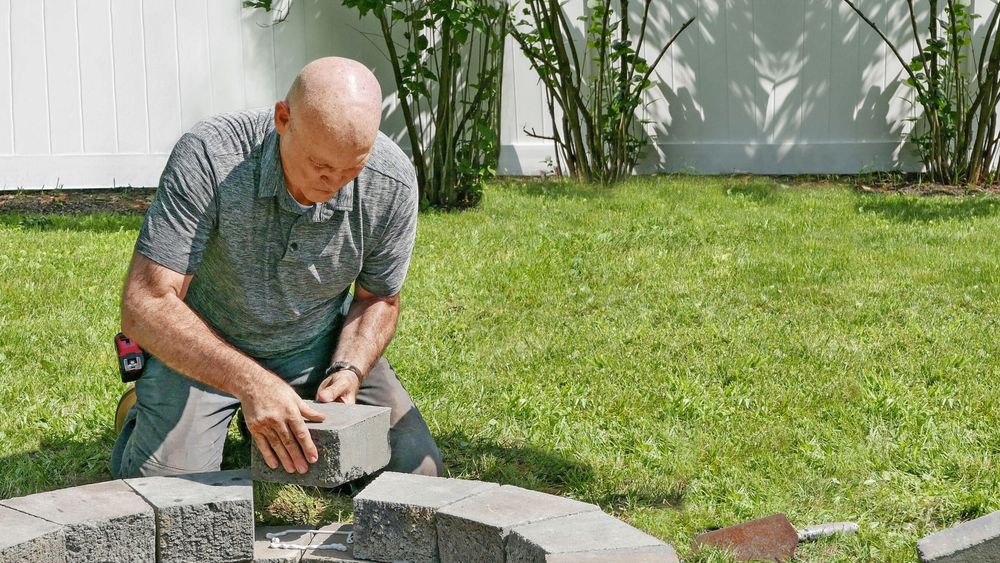 Mark McCullough adding a stone to a round firepit