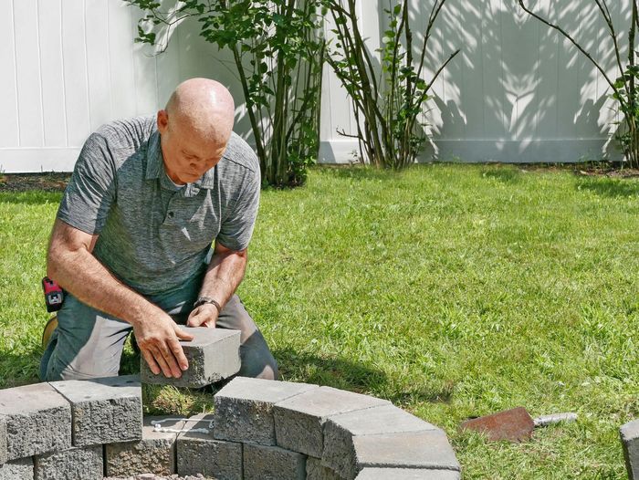 Mark McCullough adding a stone to a round firepit