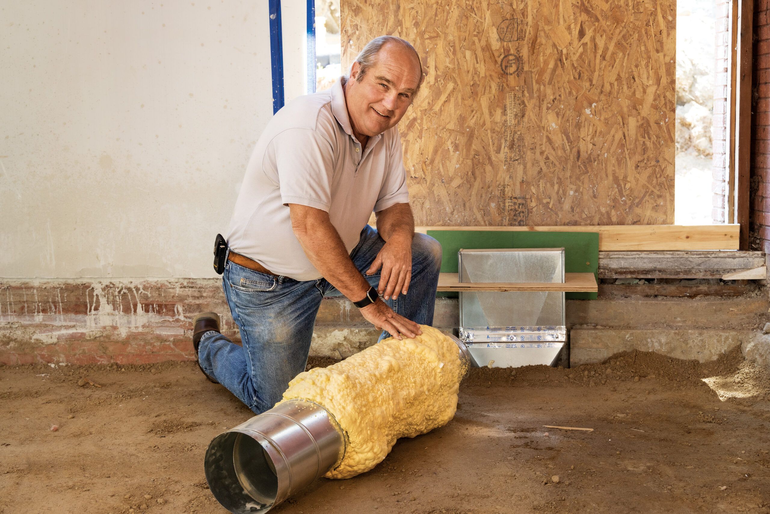 Richard Trethewey kneeling by ductwork