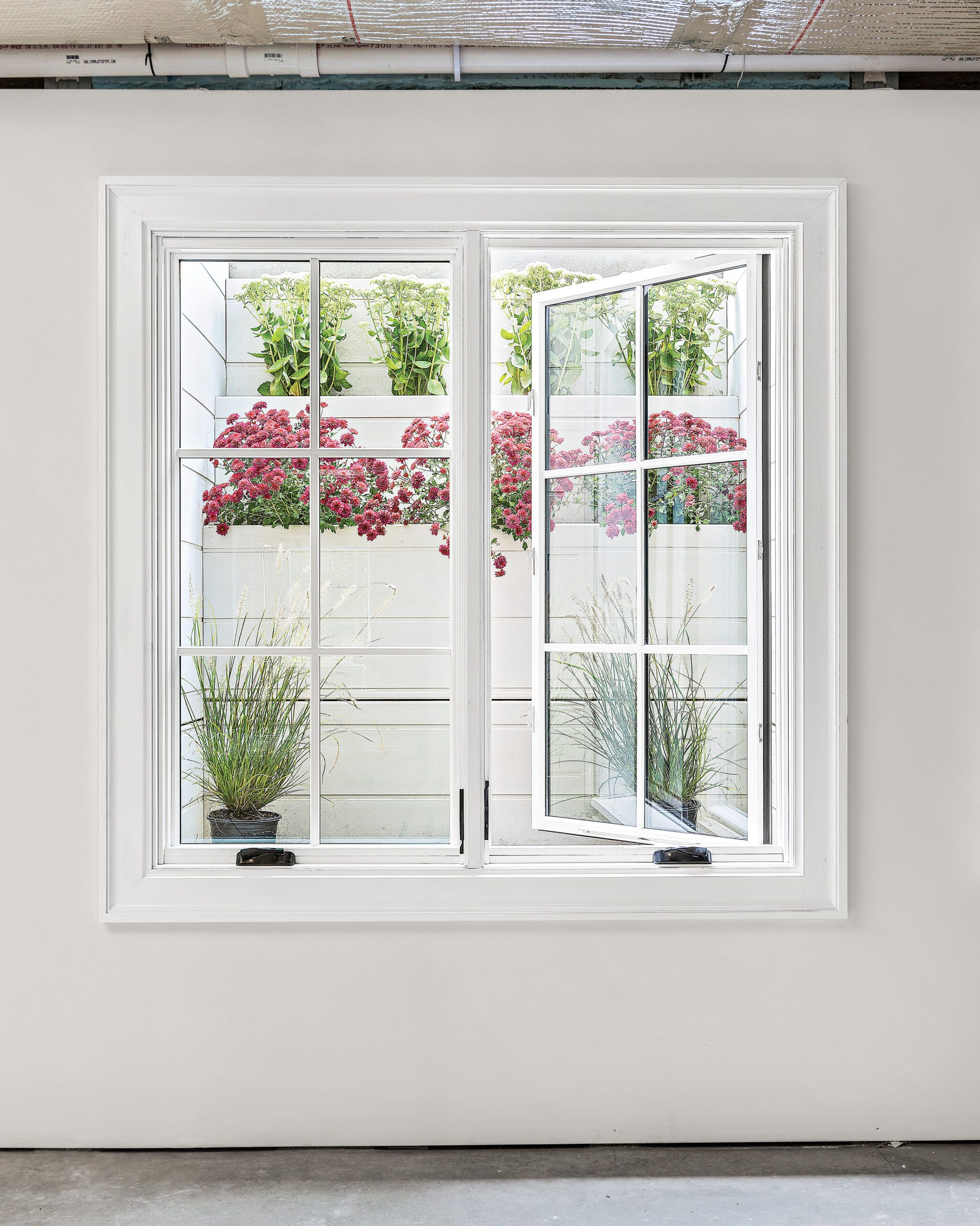 Image of an egress window within a window well for a below-ground basement