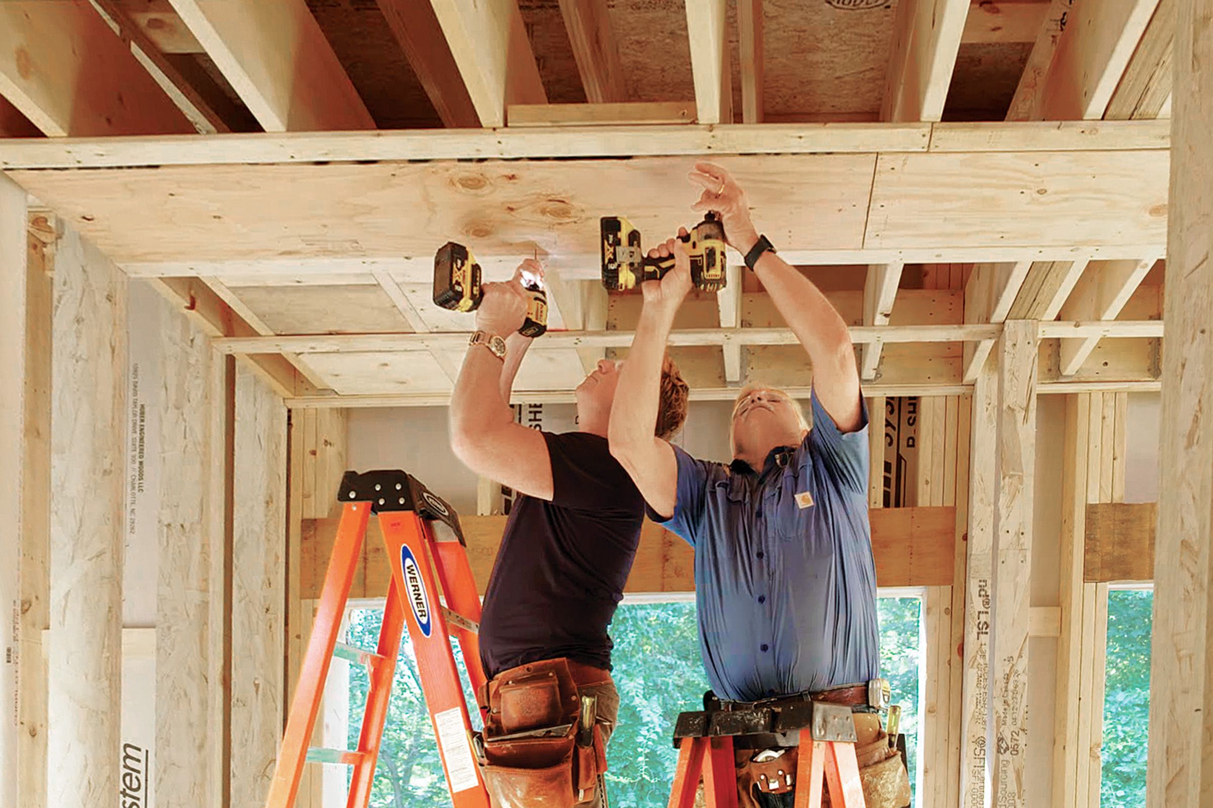 Kevin and TOH general contractor Tom Silva install blocking in Caffrey’s bedroom ceiling for a future lift system’s track.