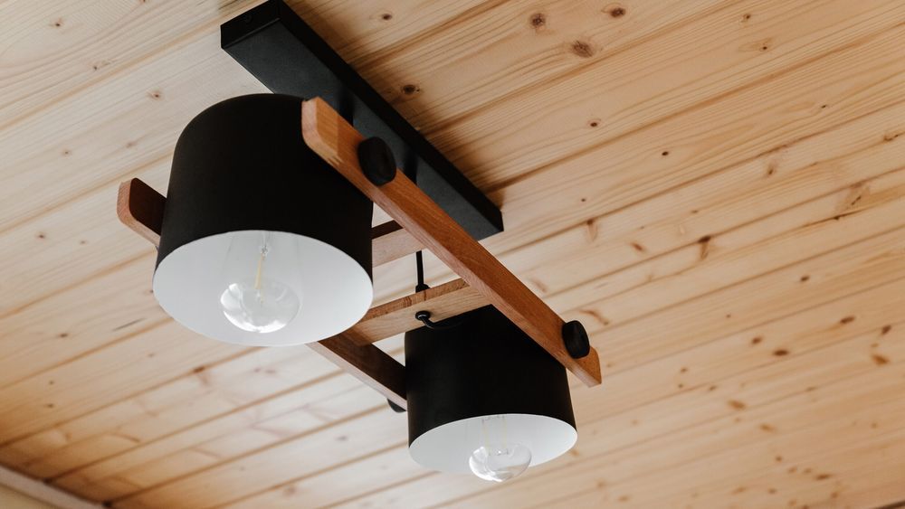 Light fixture hanging from a pine ceiling