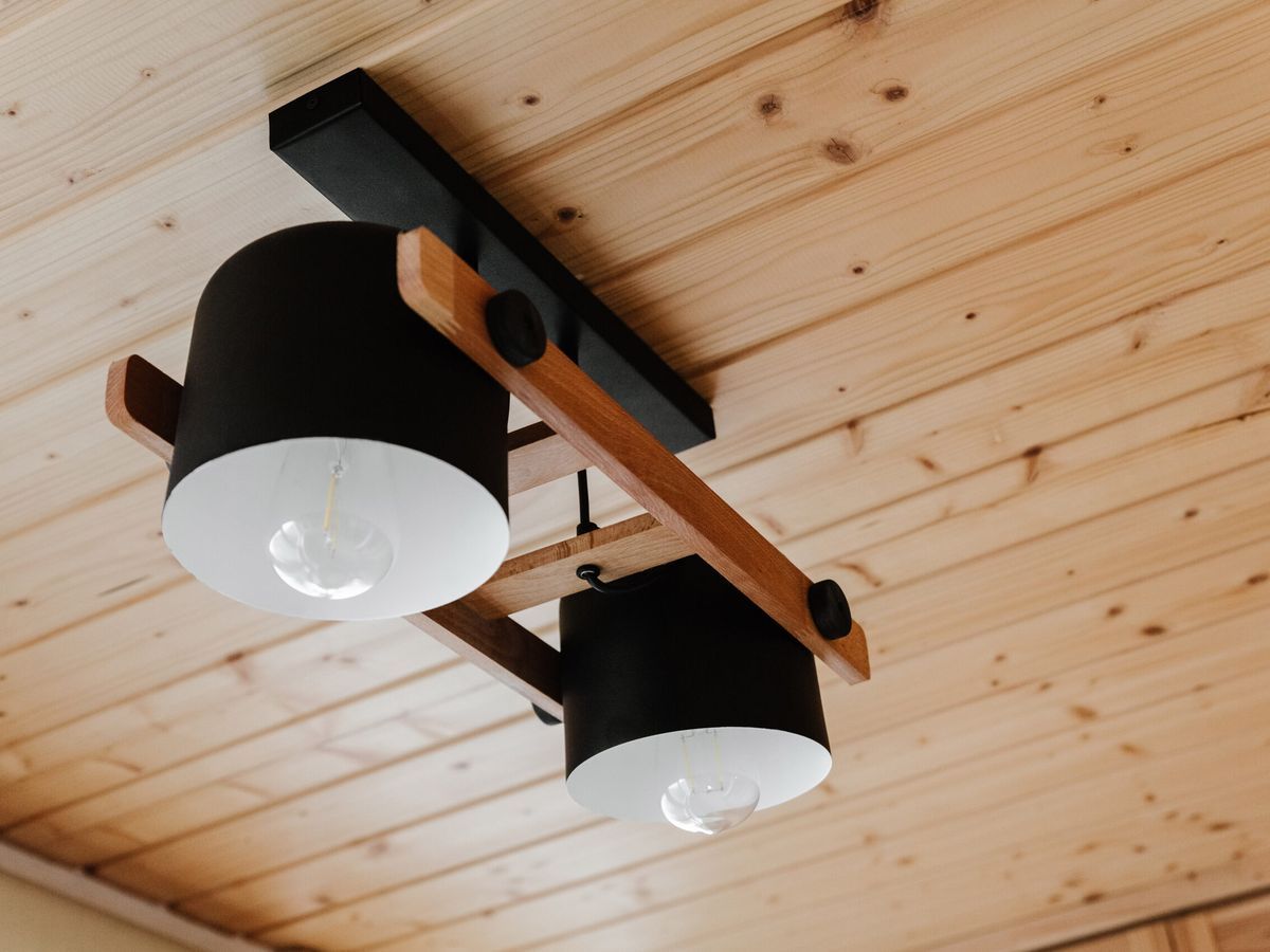 Light fixture hanging from a pine ceiling