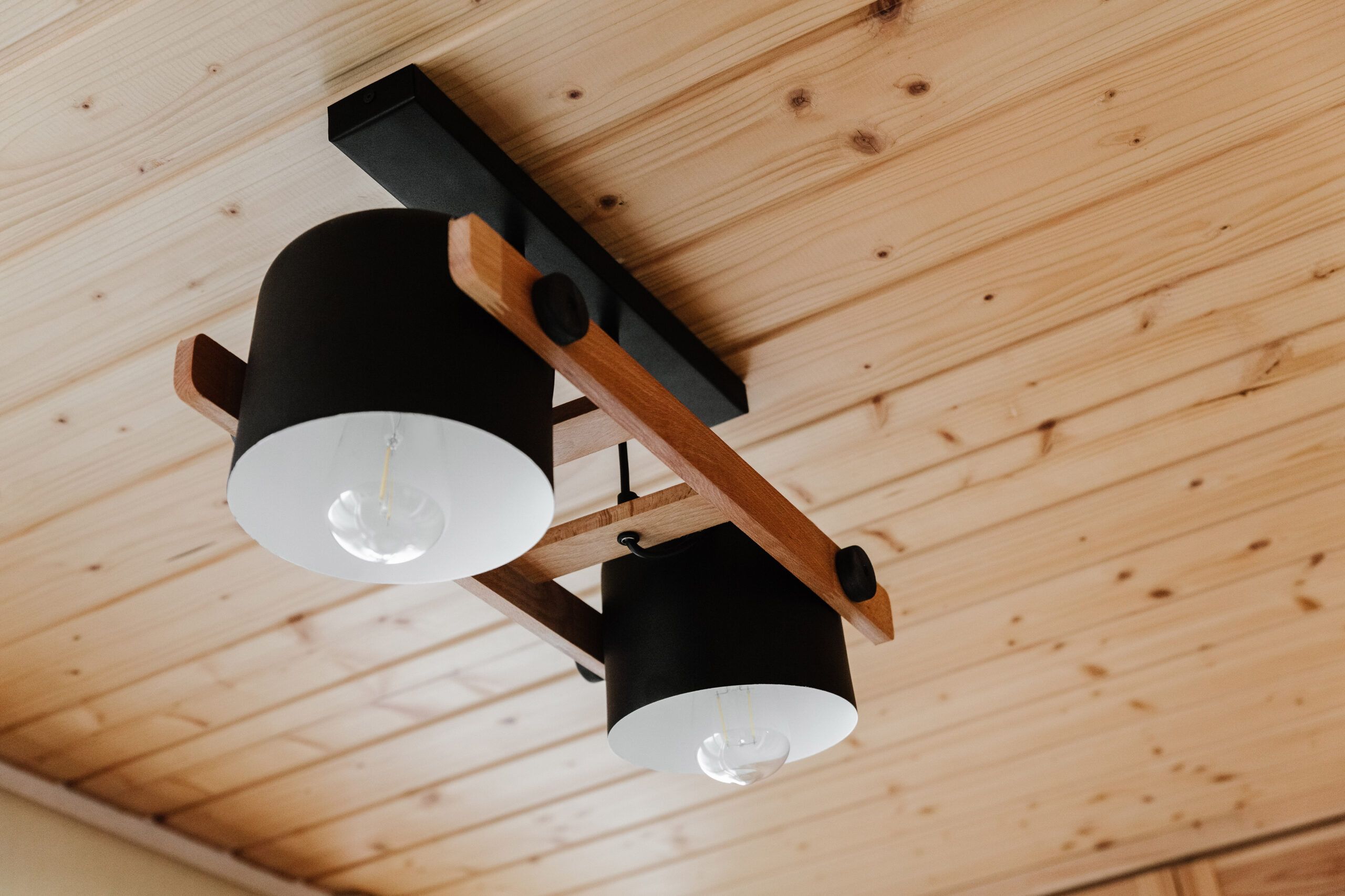 Light fixture hanging from a pine ceiling