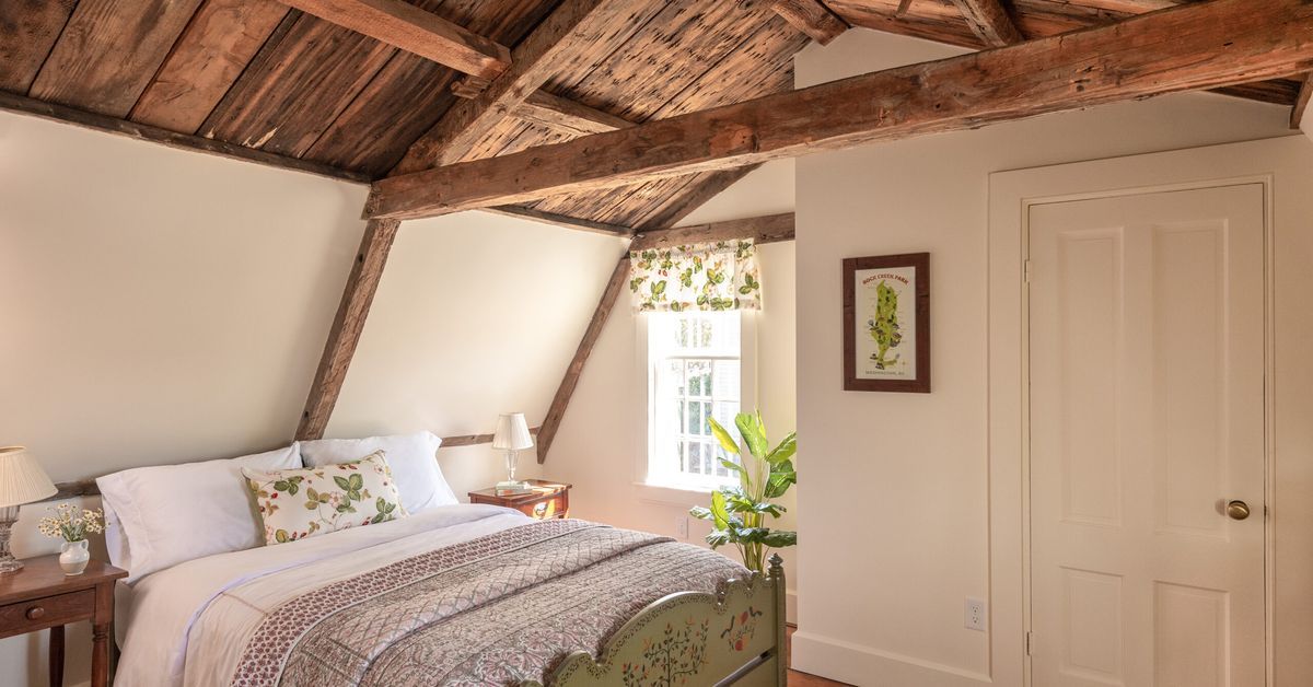Converted attic bedroom with wood rafter ceilings