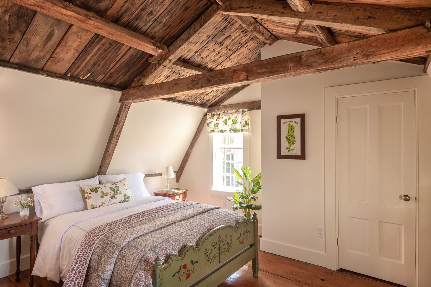 Converted attic bedroom with wood rafter ceilings