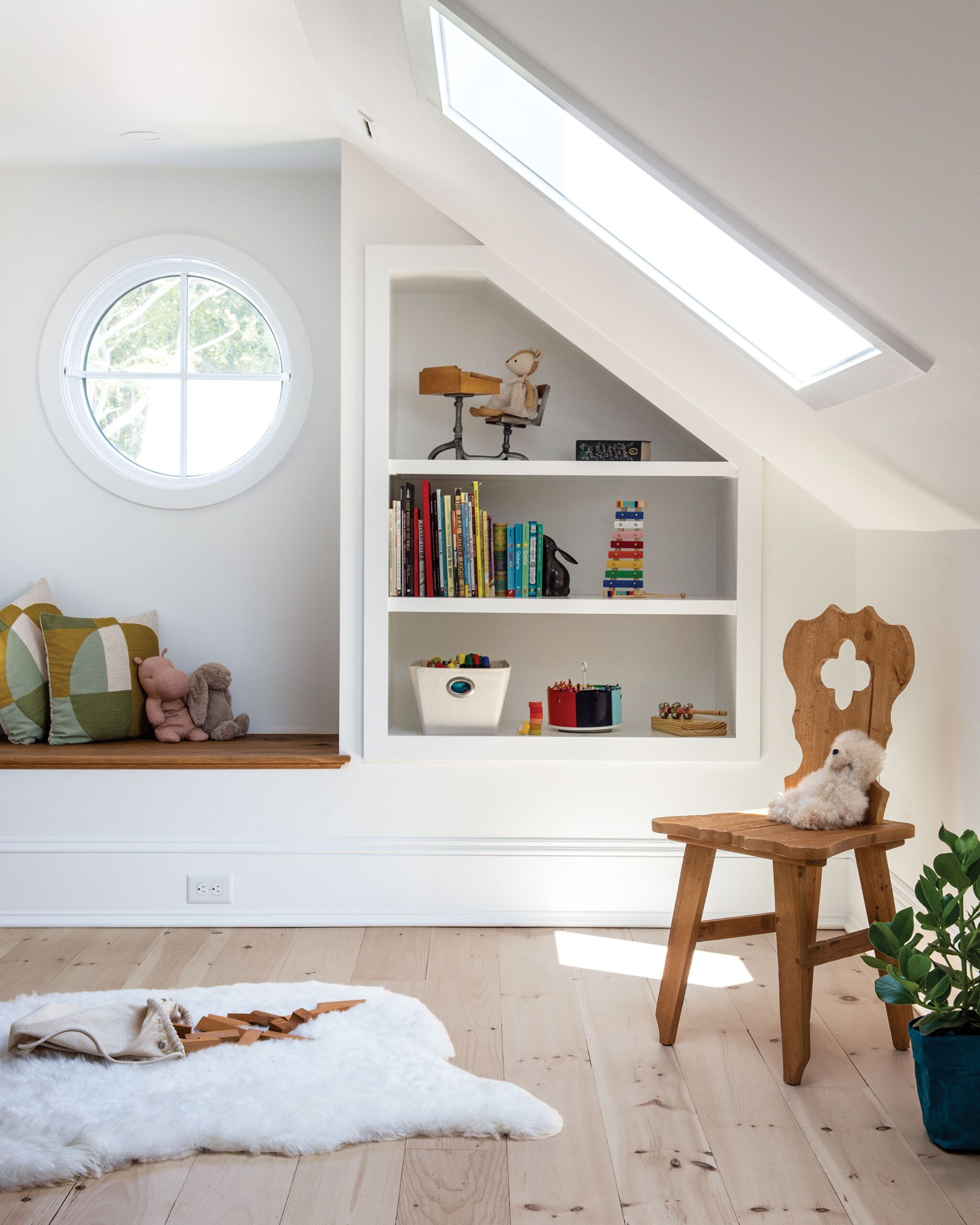 A kids play room with built in bench and wall storage.