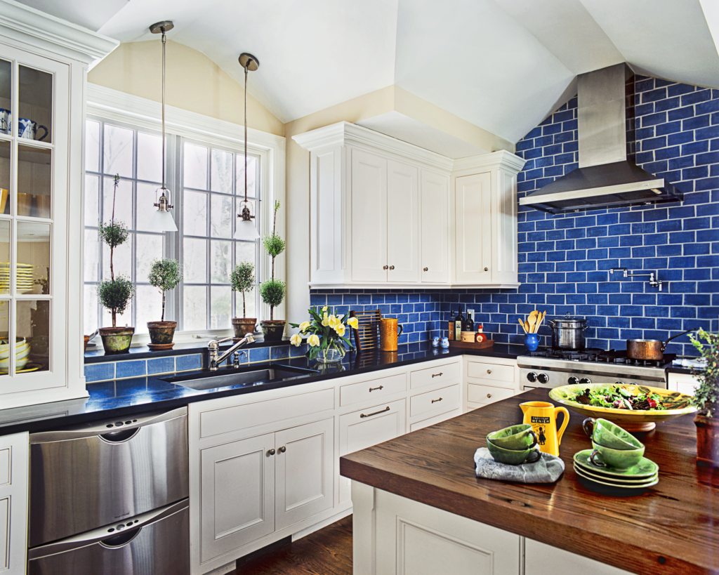 A kitchen with a bright blue ceramic subway tile backsplash.