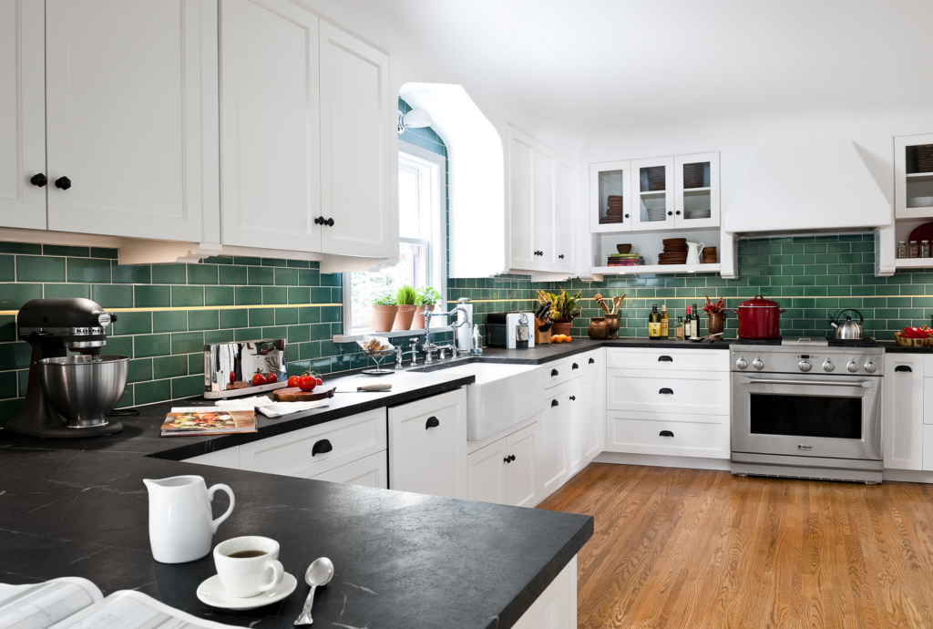 A kitchen with a green ceramic subway tile backsplash.