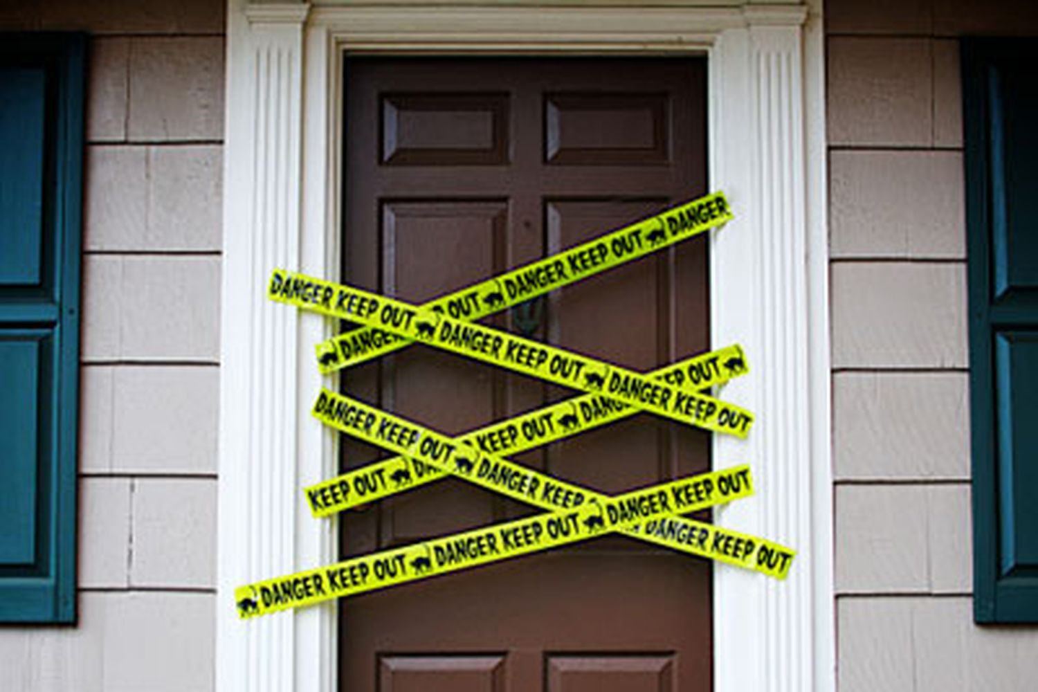 Image of a front door covered in strips of caution tape