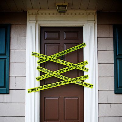 Image of a front door covered in strips of caution tape