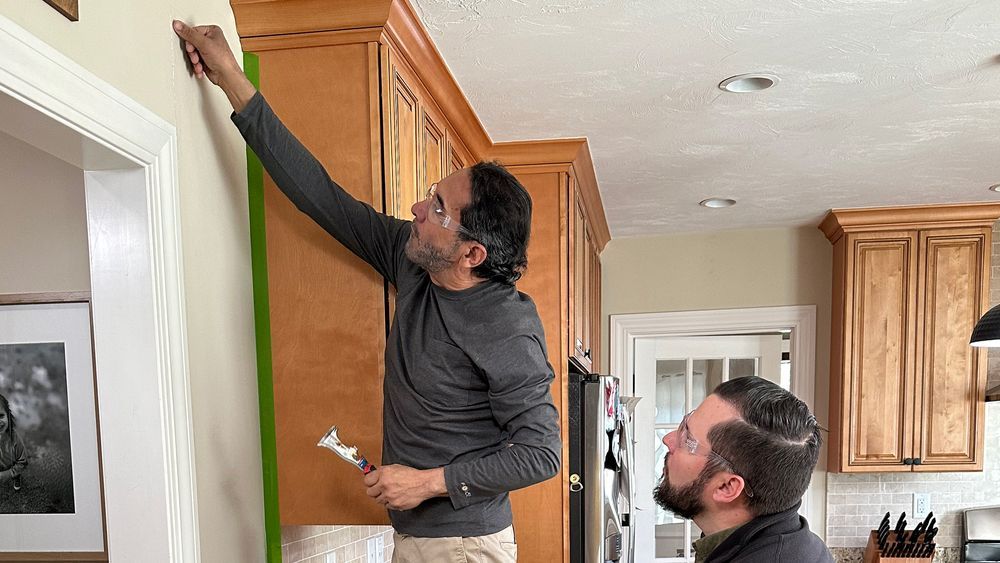 S23 E2: Mauro Henrique patches a drywall crack on a kitchen wall