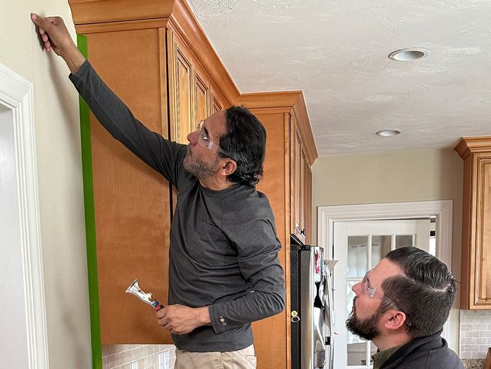 S23 E2: Mauro Henrique patches a drywall crack on a kitchen wall