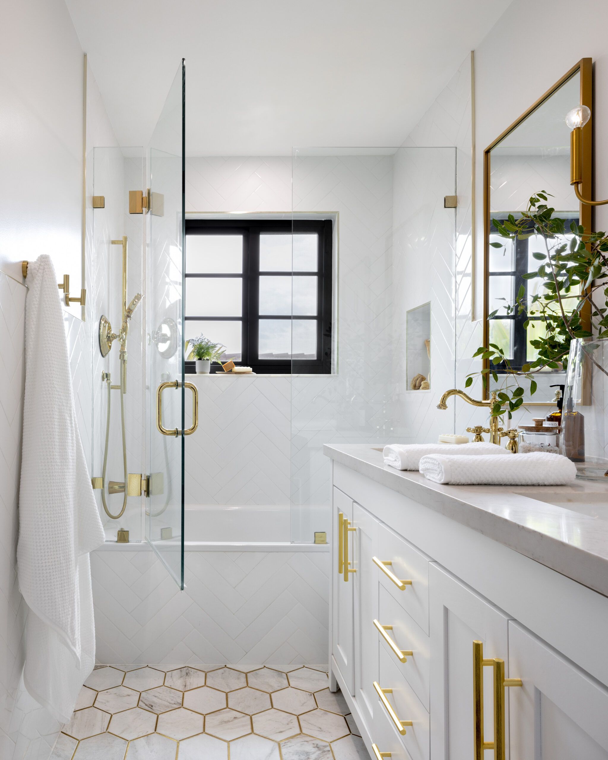 Bathroom renovated by Kathryn Fulton, White with gold accents.