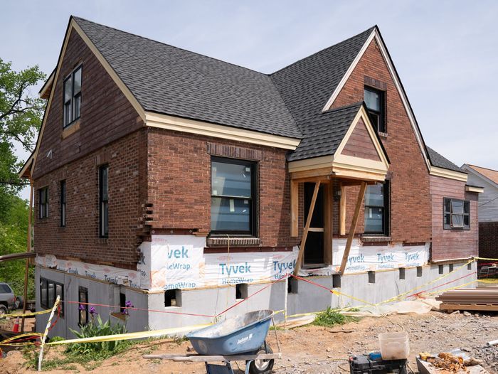 The house is back in place on top of its new foundation and house wrap adds weatherproofing around the border.