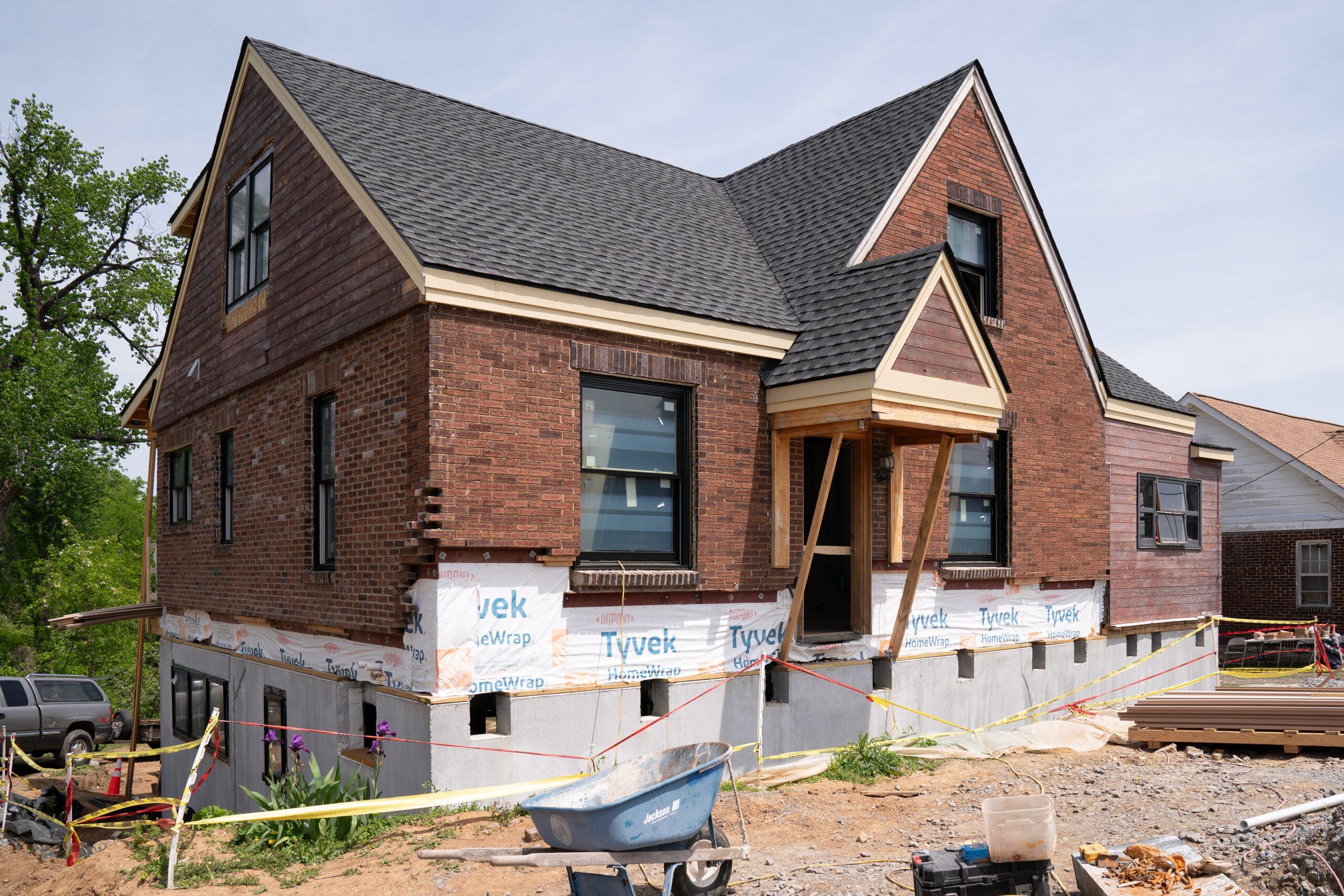 The house is back in place on top of its new foundation and house wrap adds weatherproofing around the border.