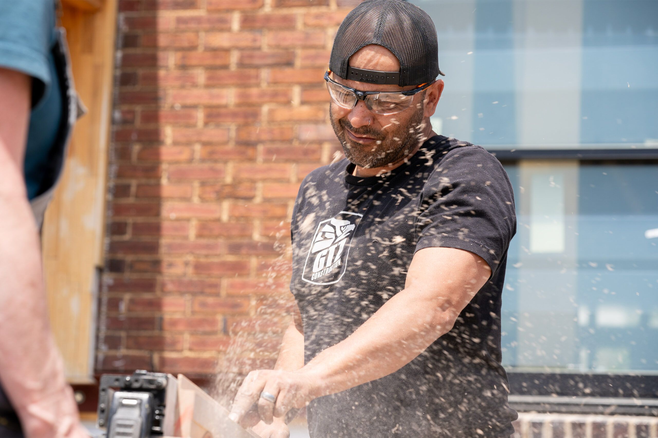 Builder Javier Gutierrez rips framing boards at a work station set up in front of the house.