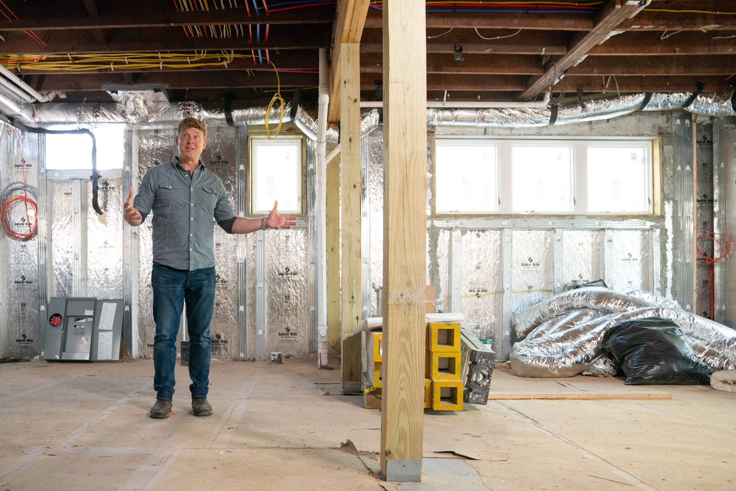 Kevin stands in the newly spacious basement, where 10-foot ceilings create plenty of headroom for future rooms.