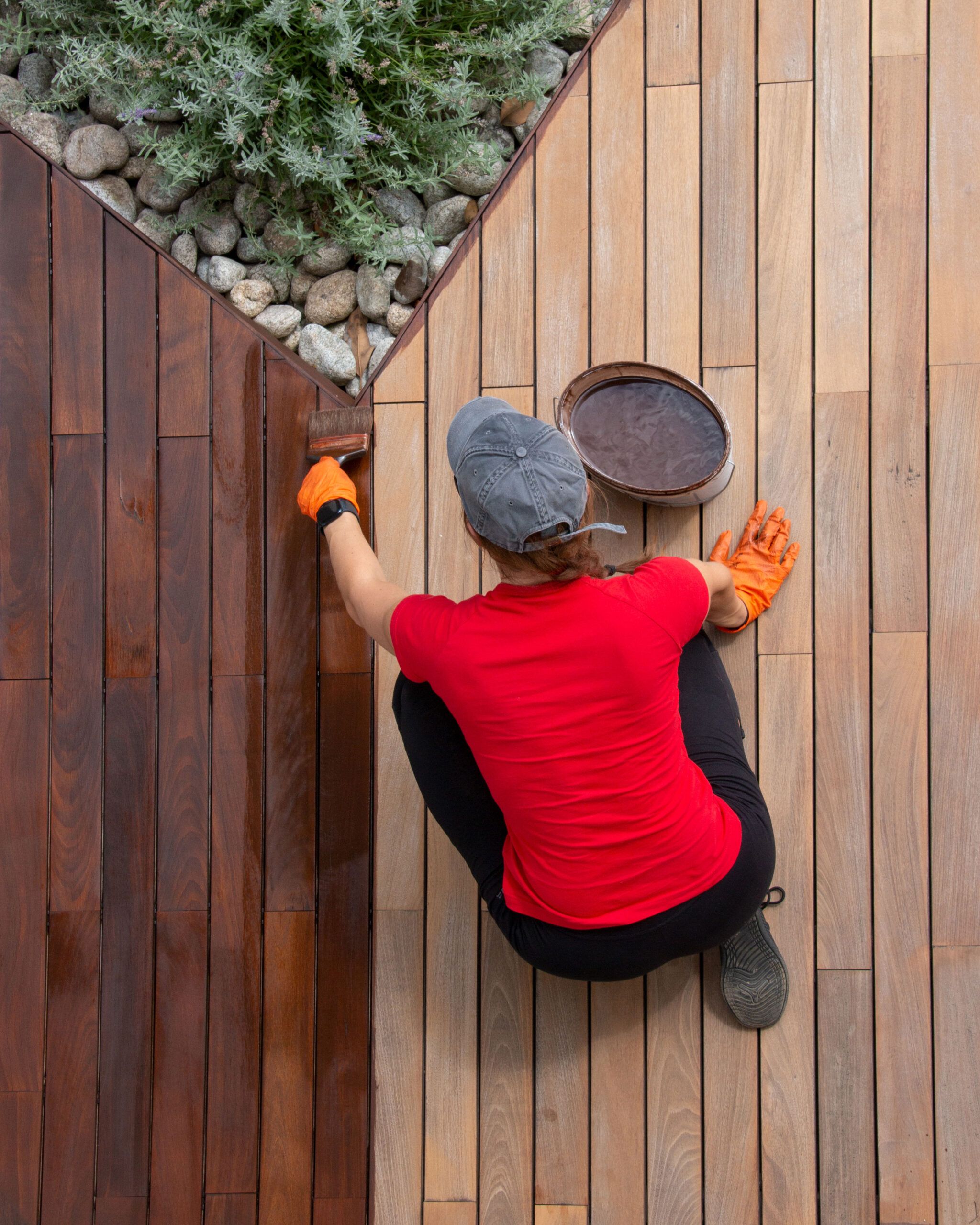 woman staining a deck