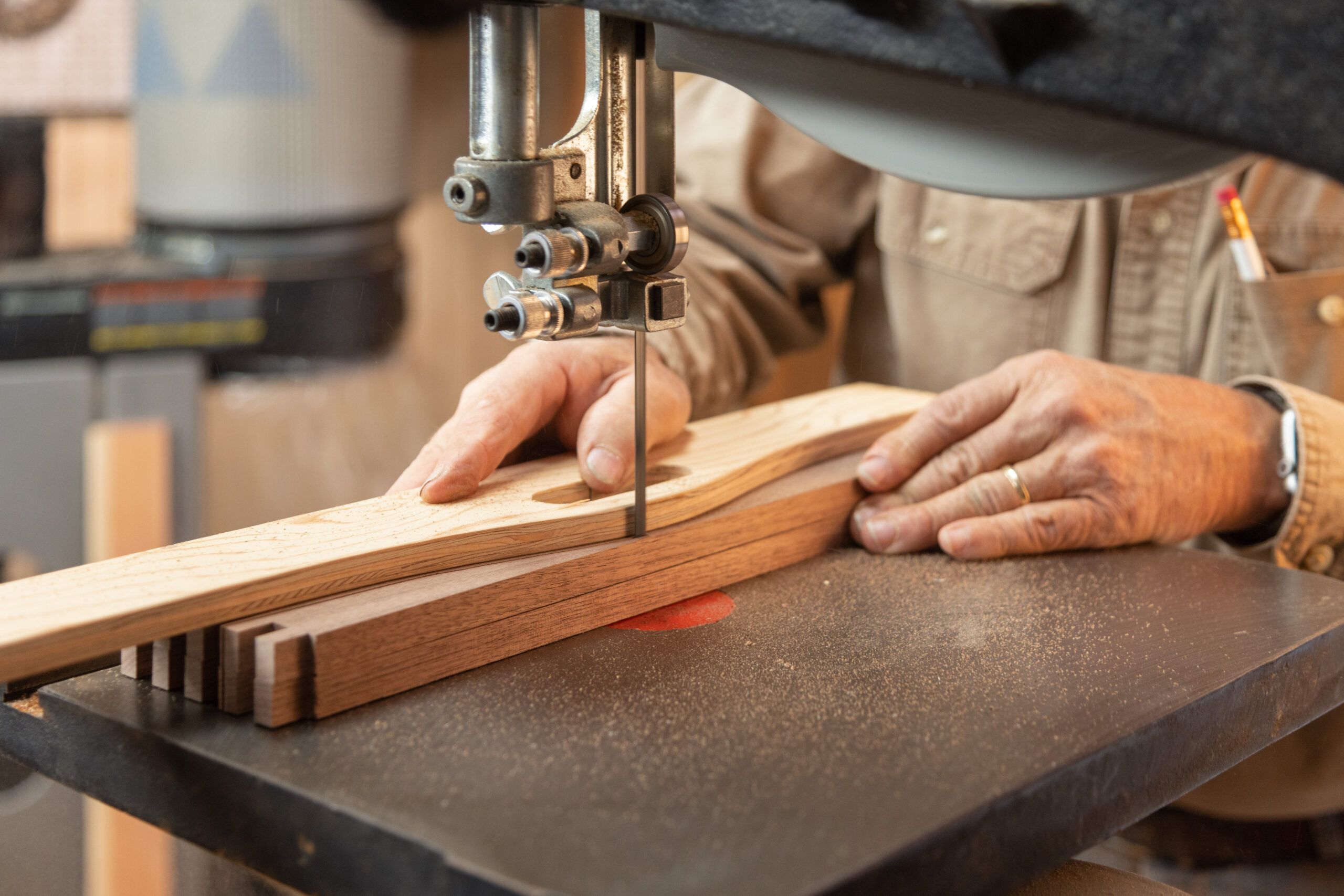 close up of hands using a band saw