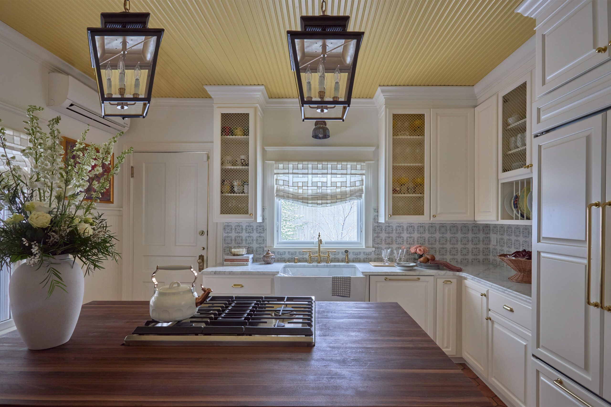 Kitchen with yellow ceiling and wooden island